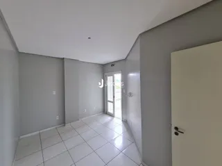 Corredor interno com piso de cerâmica claro.