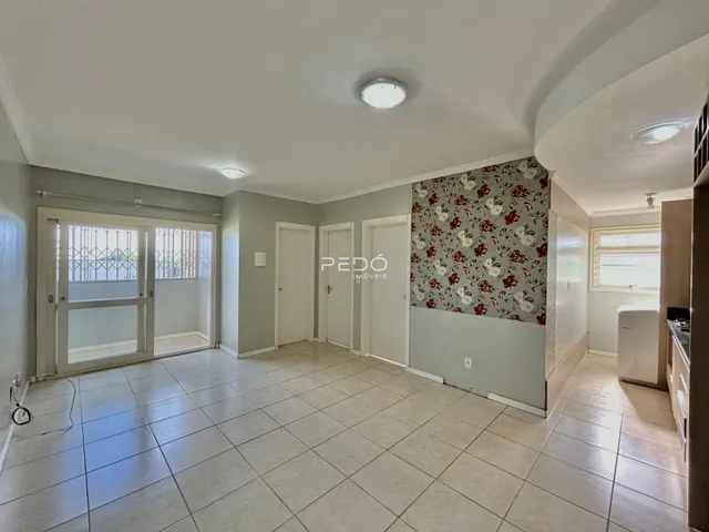 Sala de estar com piso de cerâmica clara e portas brancas.