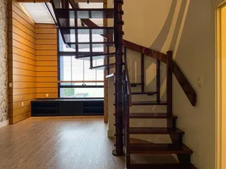 Ambiente interno com painéis de madeira e escadaria visível.