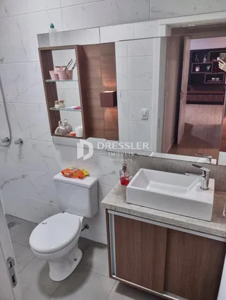 Foto de um banheiro com louças sanitárias brancas e revestimento branco.