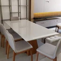Foto de uma mesa de jantar branca em um ambiente interno.