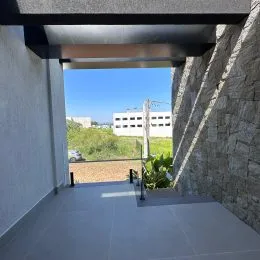 Varanda externa com piso claro e vista aberta.