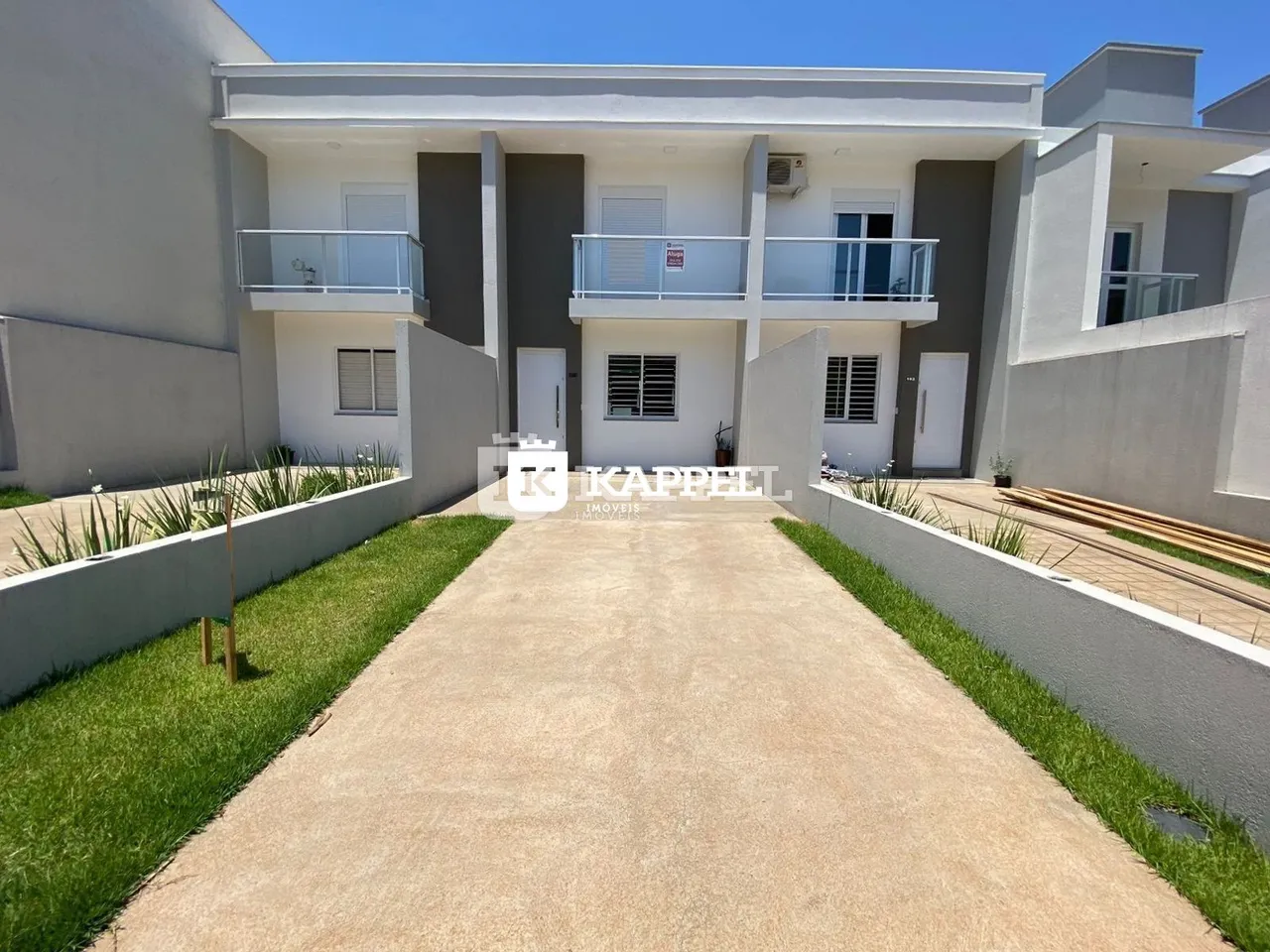 Fachada de um prédio residencial moderno com terraço e jardim em Lajeado, Brasil.