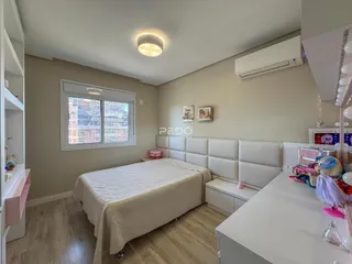 Quarto com cama e janela em ambiente claro.