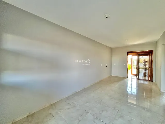 Ambiente interno de uma sala com piso de cerâmica clara e paredes brancas.