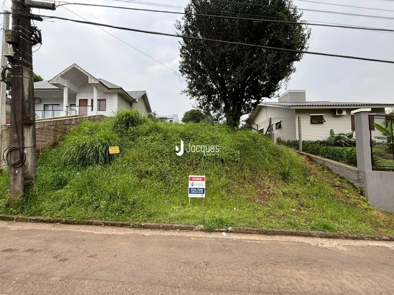 Foto de uma encosta gramada entre uma rua e residências em Lajeado.