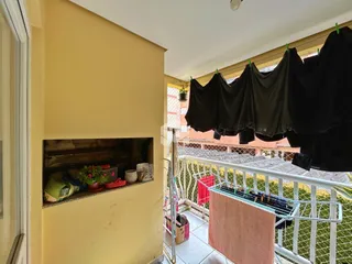 Vista de um corredor interno com nicho e acesso a uma área externa com varal.