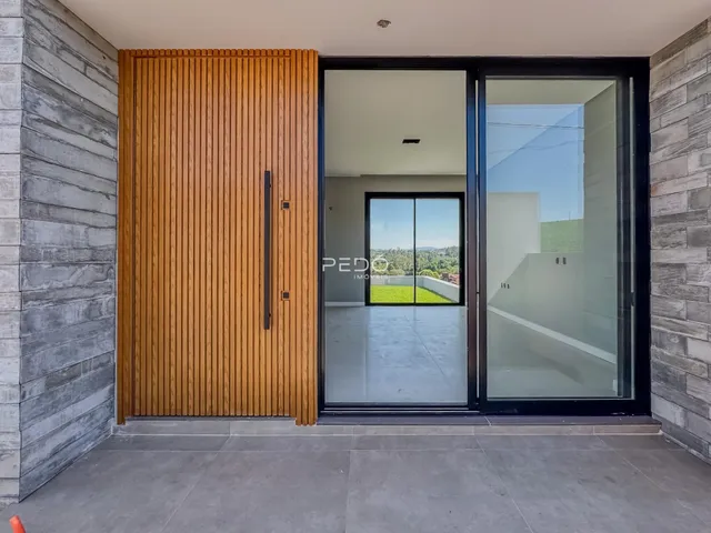 Fachada externa de uma residência com portas de vidro e revestimento de madeira.