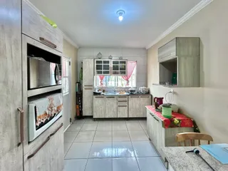 Imagem de uma cozinha com armários e piso de cerâmica em um imóvel no Brasil.