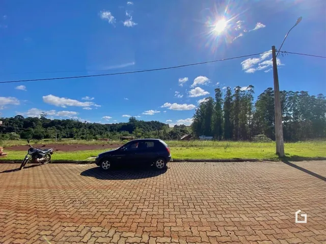 Vista externa de uma propriedade com paisagem rural ao fundo.
