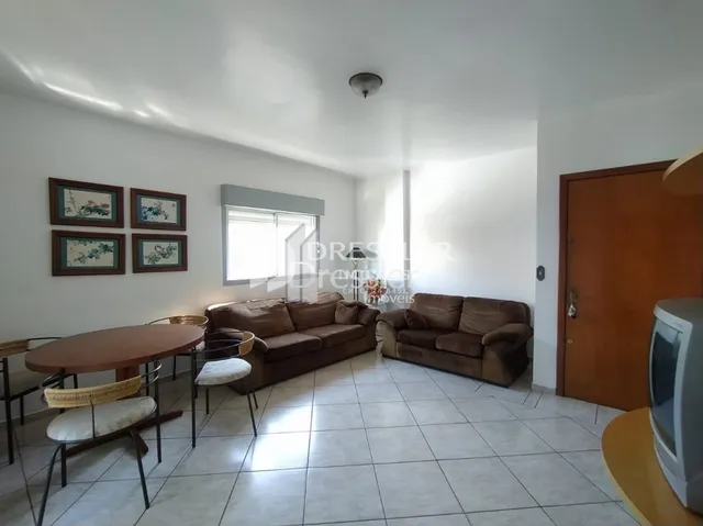 Uma sala de estar com sofá marrom e piso de cerâmica clara.