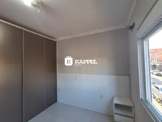 Quarto com armários embutidos e piso de cerâmica em um imóvel em Lajeado.
