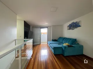 Sala de estar com piso de madeira e sofá azul.