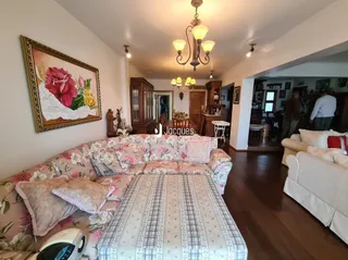 Sala de estar com sofá e piso de madeira em uma residência.
