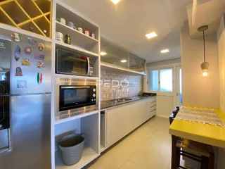 Cozinha moderna com armários brancos e eletrodomésticos de aço inoxidável.