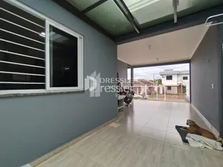 Vista interna de uma sala com parede cinza e piso claro.