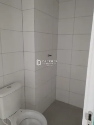 Foto de um banheiro com revestimento cerâmico branco.