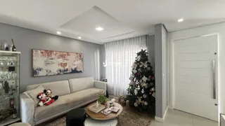 Sala de estar com sofá e árvore de Natal decorada.