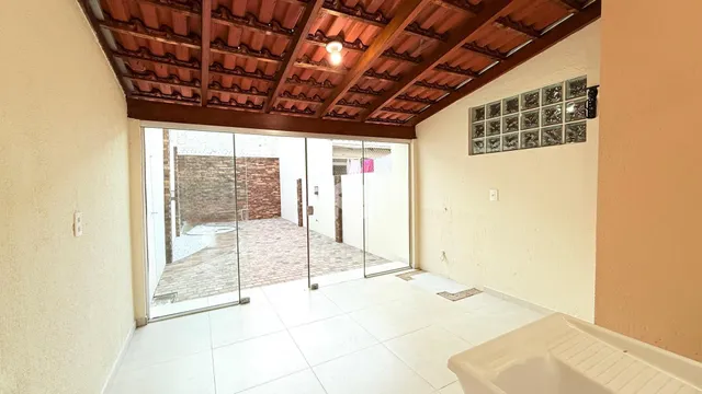 Sala de estar com portas de vidro que dão acesso a um pátio de tijolos.