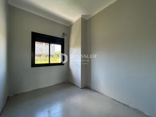 A foto mostra o interior de um cômodo com paredes brancas e piso claro.