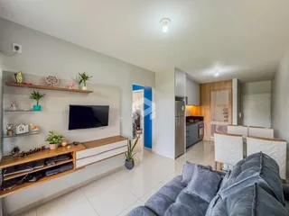 Sala de estar com sofá e televisão em um apartamento no Brasil.
