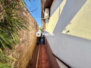 Fachada de um prédio com parede de tijolos e um caminho pavimentado.