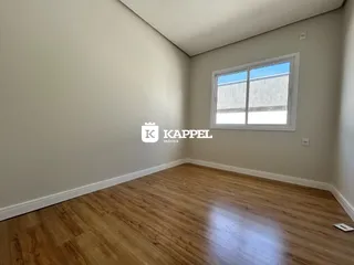 Foto de um cômodo interno com piso de madeira e uma janela.