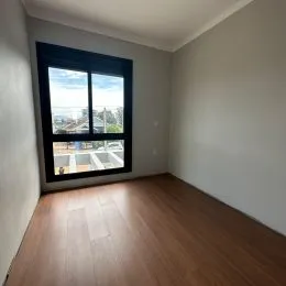 Vista de uma sala de estar com grande janela mostrando a paisagem externa.