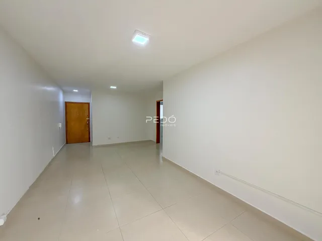 Vista ampla de um ambiente interno com piso de cerâmica clara e paredes brancas.