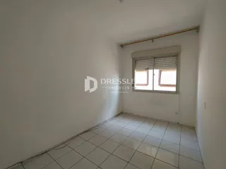Vista interna de um cômodo com piso de cerâmica e janela.