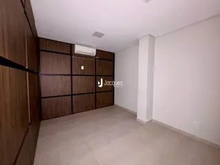 Imagem de uma sala de estar com armários em madeira e piso claro.