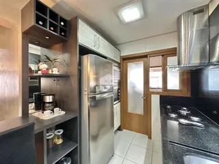 Cozinha moderna com armários e eletrodomésticos de aço inoxidável.