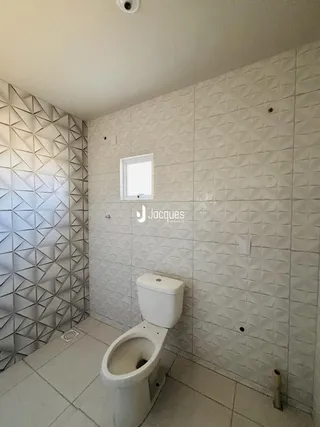 Banheiro com revestimento de parede em padrão geométrico.