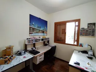 Imagem de uma sala de estar com televisão e móveis de madeira.