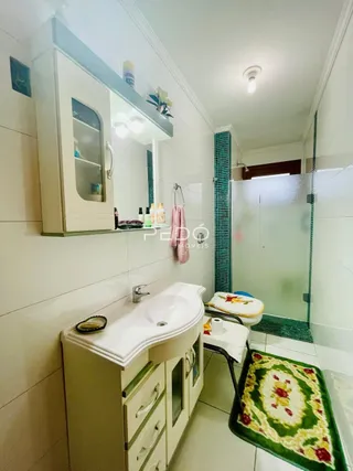 Foto de um banheiro com pia e box de vidro em uma residência.
