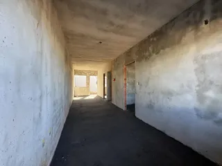 Corredor longo e sem acabamento em uma residência.