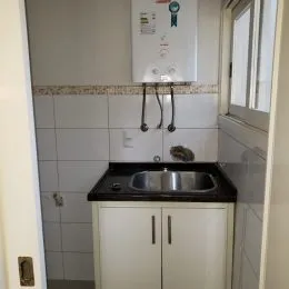 Foto de uma bancada com pia e armários na cozinha.