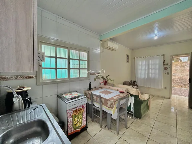 Vista interna de uma cozinha com janela e área de jantar em Lajeado.