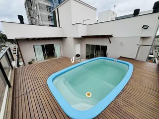 Fachada de uma residência com deck e piscina no Brasil.