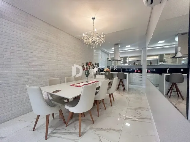 Sala de jantar com piso de mármore branco e paredes de tijolo branco.