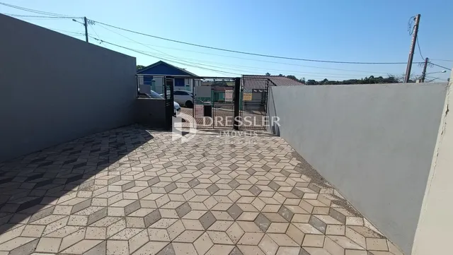 Pátio externo com piso de ladrilhos no lote em Lajeado.