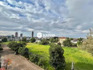 Uma vista aérea da paisagem urbana de Lajeado, Brasil, mostrando áreas verdes e edifícios ao fundo.