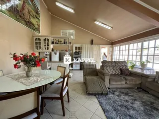 Sala de estar com mesa de jantar e sofá em um apartamento em Lajeado.
