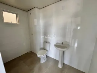 Banheiro com piso de cerâmica e louças brancas.
