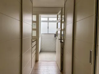 Hall de entrada com piso de madeira e paredes claras.