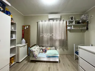 Foto de um quarto com cama e armários brancos em um imóvel.