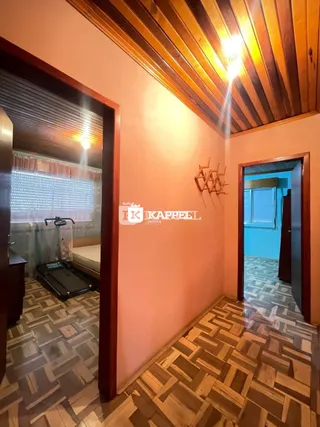 Hall de entrada com piso de ladrilhos e forro de madeira.
