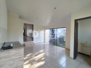 Interior de uma sala com piso de cerâmica e porta de vidro.