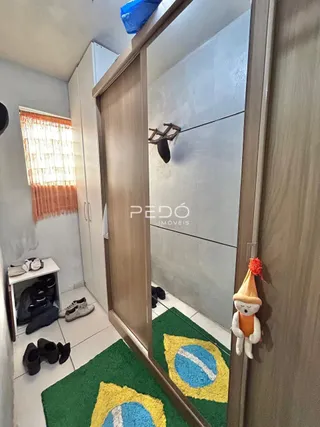 Hall de entrada com piso de cerâmica e tapete verde em um imóvel no Brasil.