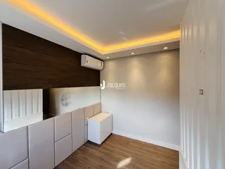 Interior de uma sala com painel de madeira e piso de madeira.